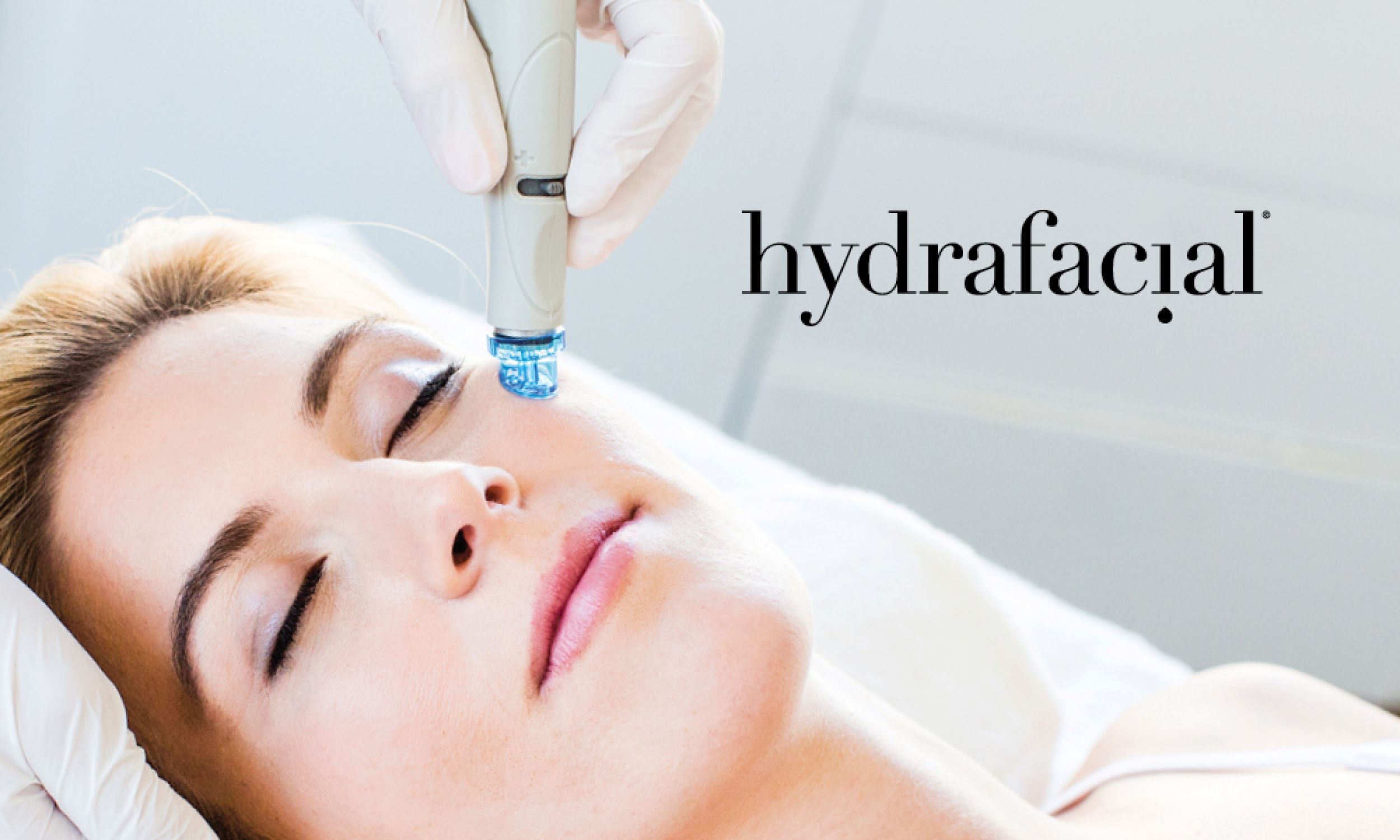 Kosmetikerin führt das HydraFacial-Handstück über die Stirn einer liegenden Kundin