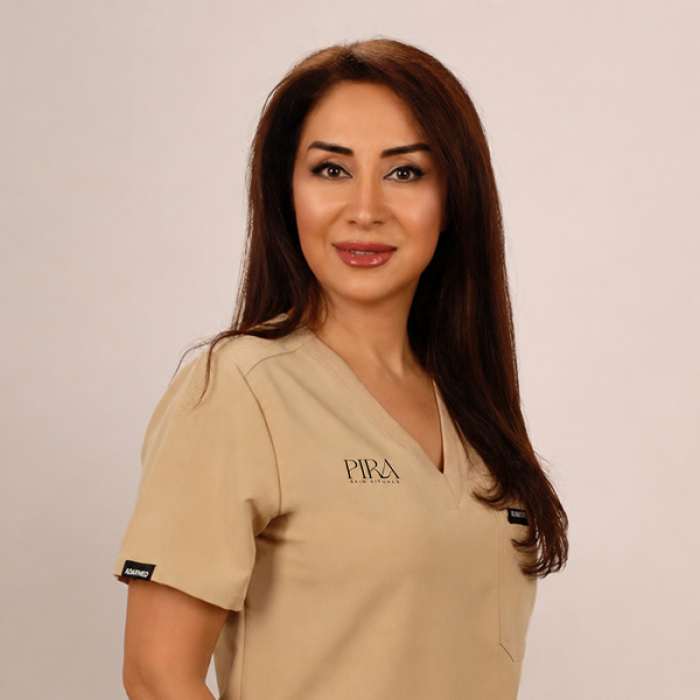 Zohreh Chamanpira in beiger Berufskleidung, Pira-Skin-Rituals-Logo auf der Brust