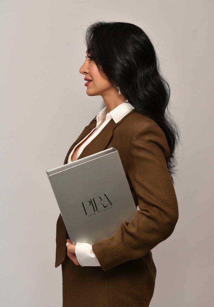 Zohreh Chamanpira im Profil mit der geschlossenen Pira Skin Rituals Box unter dem Arm