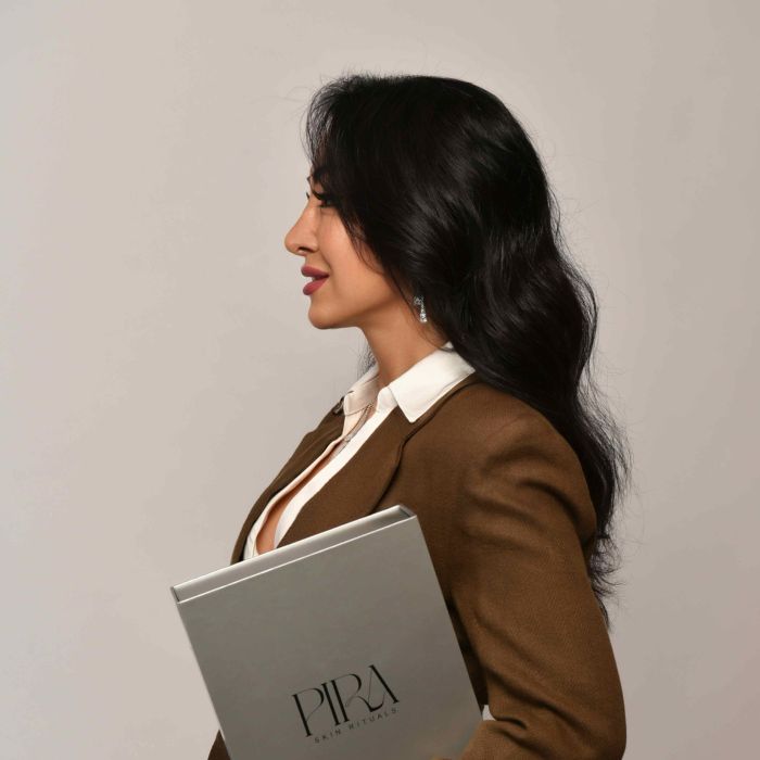 Zohreh Chamanpira im Profil mit der geschlossenen Pira Skin Rituals Box unter dem Arm